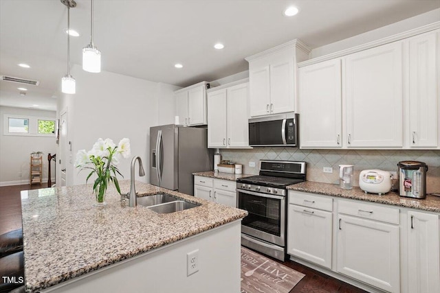 1041 Cotulla Dr, Morrisville, NC 27560 - kitchen featuring appliances with stainless steel finishes, a kitchen island with sink, white cabinetry, backsplash, and visible vents