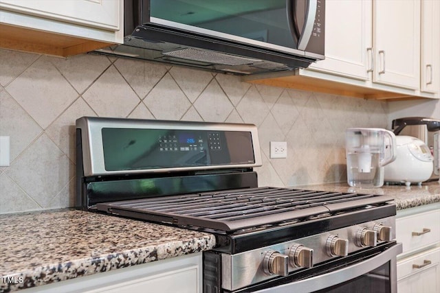 1041 Cotulla Dr, Morrisville, NC 27560 - details with stainless steel range with gas stovetop, tasteful backsplash, light stone countertops, and white cabinets