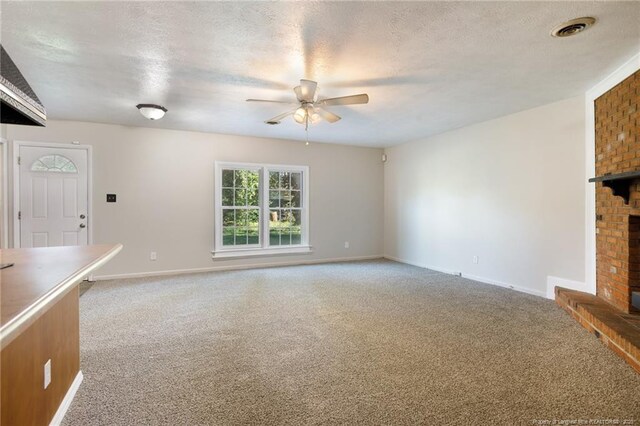 6506 Sprucewood Rd, Fayetteville, NC 28304 - unfurnished living room featuring ceiling fan, a textured ceiling, visible vents, light carpet, and a brick fireplace