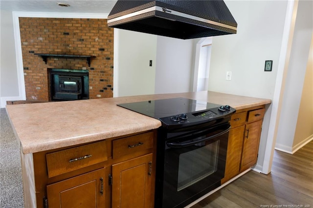 6506 Sprucewood Rd, Fayetteville, NC 28304 - kitchen featuring baseboards, wall chimney range hood, brown cabinets, dark wood-type flooring, and electric range