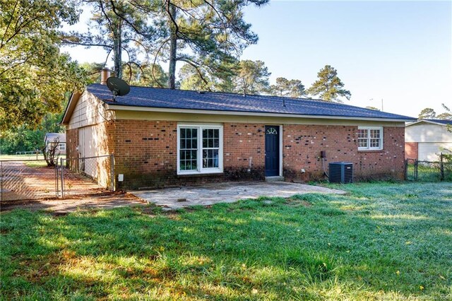6506 Sprucewood Rd, Fayetteville, NC 28304 - rear view of property featuring central AC, a lawn, fence, a patio, and brick siding