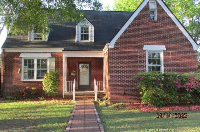 203 W 16th St, Lumberton, NC 28358 - cape cod home featuring a front lawn and brick siding