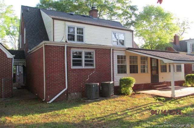 203 W 16th St, Lumberton, NC 28358 - rear view of property with entry steps, a patio area, brick siding, a chimney, and central AC unit