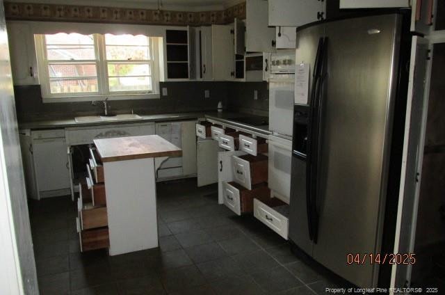 203 W 16th St, Lumberton, NC 28358 - kitchen with dark tile patterned floors, white appliances, a kitchen island, white cabinets, and a sink