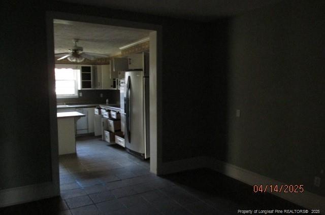203 W 16th St, Lumberton, NC 28358 - kitchen featuring light countertops, ceiling fan, freestanding refrigerator, dark tile patterned floors, and white cabinetry
