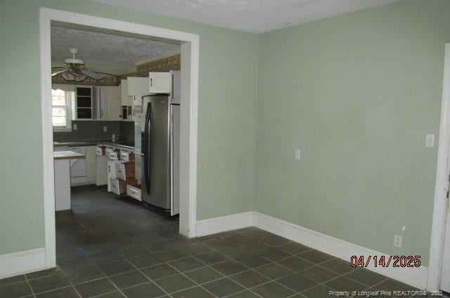 203 W 16th St, Lumberton, NC 28358 - kitchen featuring dark tile patterned flooring, freestanding refrigerator, ceiling fan, and white cabinetry