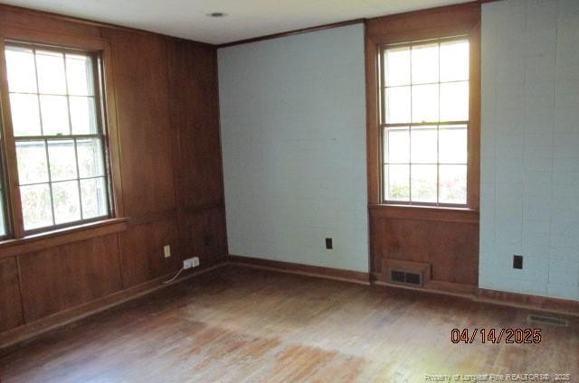 203 W 16th St, Lumberton, NC 28358 - spare room featuring wood finished floors, baseboards, visible vents, and a wealth of natural light