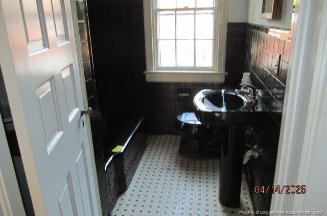 203 W 16th St, Lumberton, NC 28358 - bathroom featuring tile patterned floors, decorative backsplash, and a sink