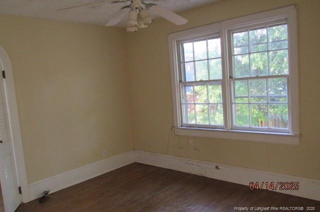 203 W 16th St, Lumberton, NC 28358 - unfurnished room featuring arched walkways, dark wood-style flooring, baseboards, and ceiling fan