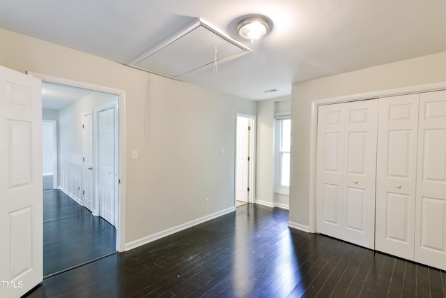 6409 Lakeland Dr, Raleigh, NC 27612 - unfurnished bedroom with attic access, dark wood-style flooring, baseboards, and a closet