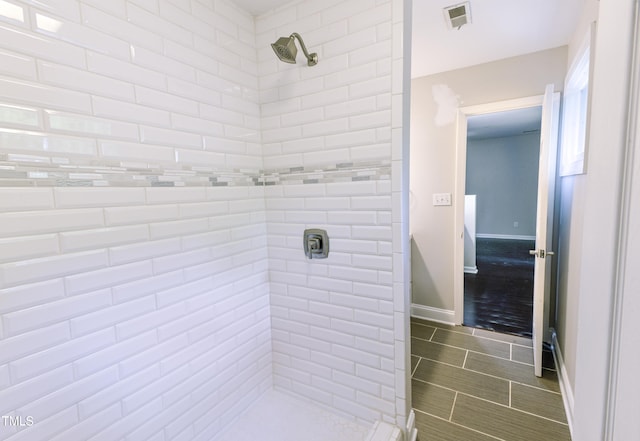6409 Lakeland Dr, Raleigh, NC 27612 - bathroom featuring a tile shower and baseboards