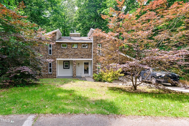 6409 Lakeland Dr, Raleigh, NC 27612 - view of front facade with stone siding, a chimney, and a front lawn