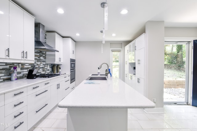6409 Lakeland Dr, Raleigh, NC 27612 - kitchen with a sink, wall chimney range hood, stainless steel appliances, a kitchen island with sink, and decorative backsplash