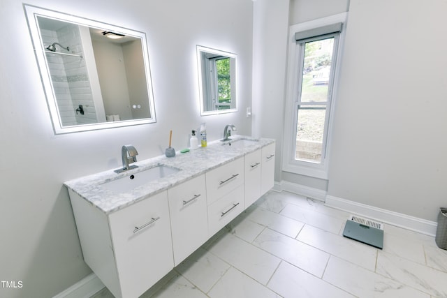 6409 Lakeland Dr, Raleigh, NC 27612 - full bathroom with marble look tile flooring, baseboards, double vanity, and a tile shower