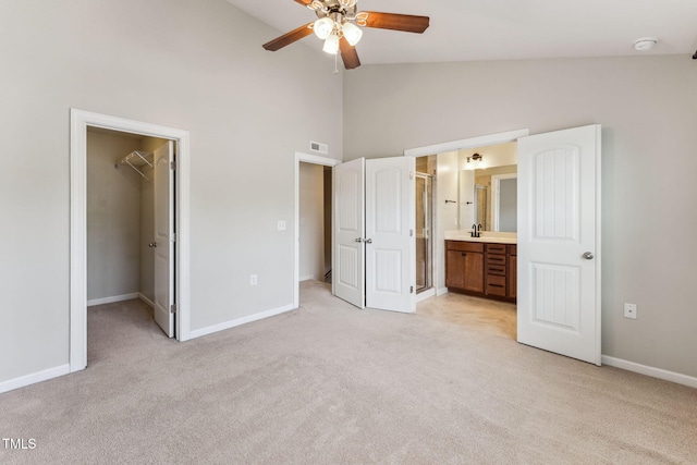 2027 Hayes Ln, Holly Springs, NC 27540 - unfurnished bedroom with light carpet, a walk in closet, baseboards, connected bathroom, and high vaulted ceiling