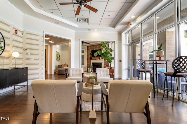 2027 Hayes Ln, Holly Springs, NC 27540 - dining room with ceiling fan, wood finished floors, a raised ceiling, and a fireplace