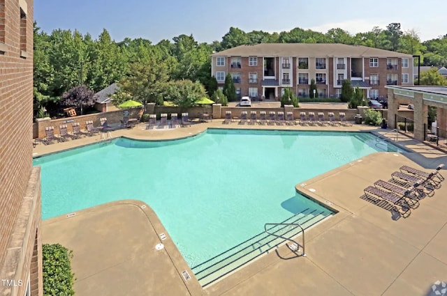 2027 Hayes Ln, Holly Springs, NC 27540 - community pool featuring a patio area and view of wooded area