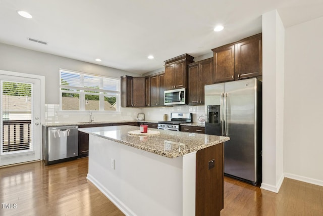 2027 Hayes Ln, Holly Springs, NC 27540 - kitchen with stainless steel appliances, a sink, a center island, dark brown cabinetry, and recessed lighting