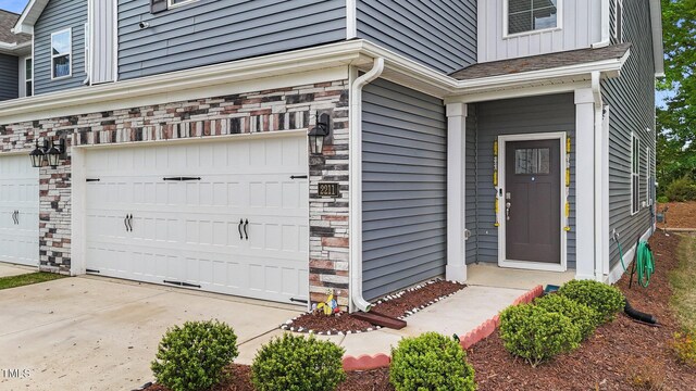 2211 Cherry Top Dr, Fuquay Varina, NC 27526 - doorway to property with stone siding and a garage