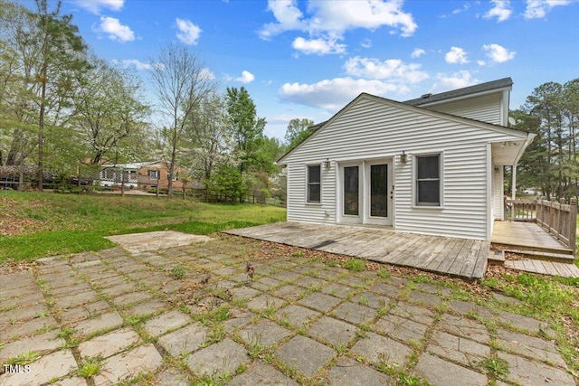 rear view of house featuring a yard, a deck, and fence