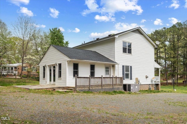 rear view of house featuring roof with shingles, a deck, and central air condition unit