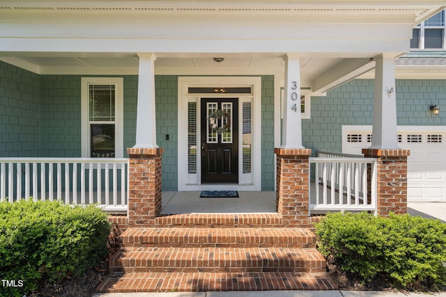 entrance to property featuring an attached garage and a porch