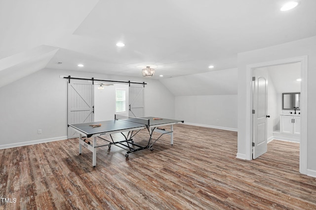 playroom featuring recessed lighting, vaulted ceiling, a barn door, and wood finished floors