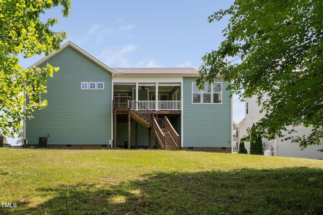 rear view of property with a lawn, ceiling fan, stairway, and crawl space