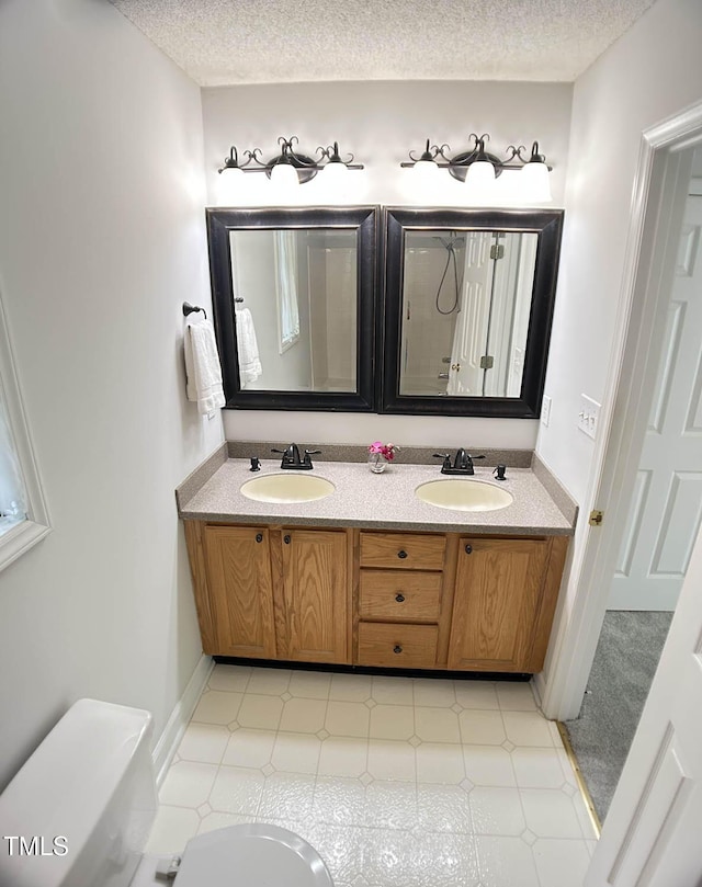 109 Elmview Dr, Cary, NC 27519 - bathroom featuring double vanity, toilet, a textured ceiling, and a shower