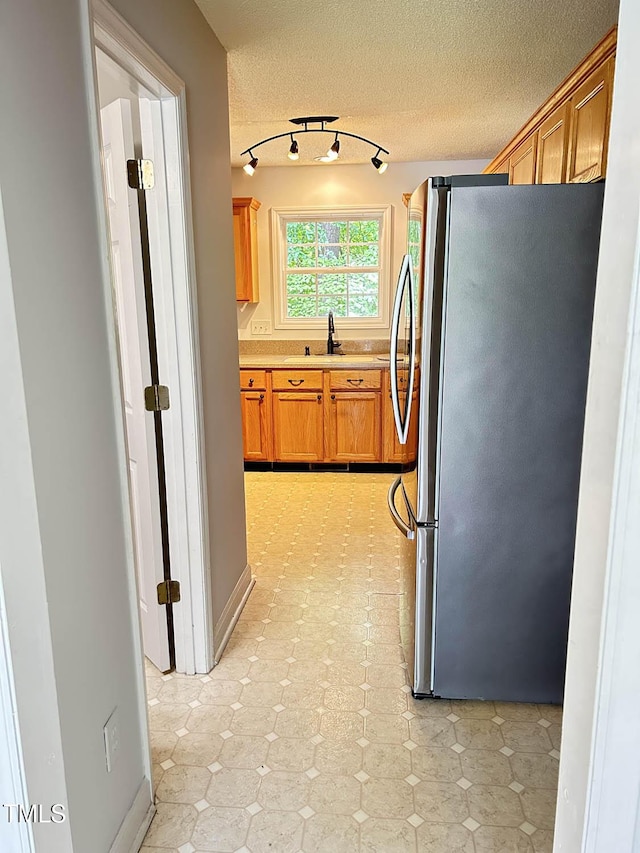 109 Elmview Dr, Cary, NC 27519 - kitchen featuring freestanding refrigerator, light countertops, a textured ceiling, a sink, and light floors