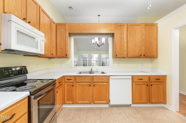kitchen featuring an inviting chandelier, a sink, white appliances, and light countertops