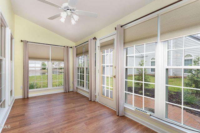 unfurnished sunroom featuring vaulted ceiling and wood finished floors