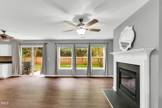 105 Ryder Cup Cir, Raleigh, NC 27603 - unfurnished living room with ceiling fan, a glass covered fireplace, dark wood-type flooring, and baseboards