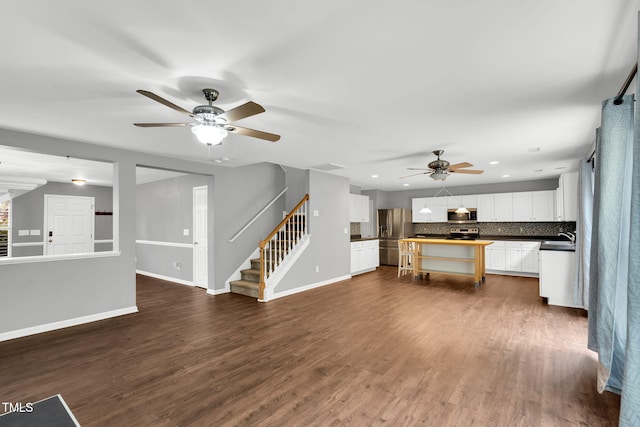 105 Ryder Cup Cir, Raleigh, NC 27603 - unfurnished living room with ceiling fan, stairway, baseboards, recessed lighting, and dark wood-style floors