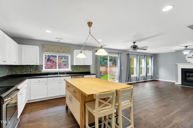 105 Ryder Cup Cir, Raleigh, NC 27603 - kitchen with a sink, wood counters, stainless steel electric range oven, decorative backsplash, and a ceiling fan