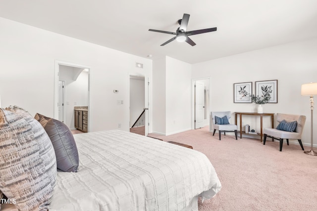 bedroom featuring connected bathroom, baseboards, light carpet, and ceiling fan