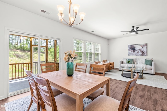 dining space featuring baseboards, ceiling fan with notable chandelier, light wood-type flooring, and visible vents
