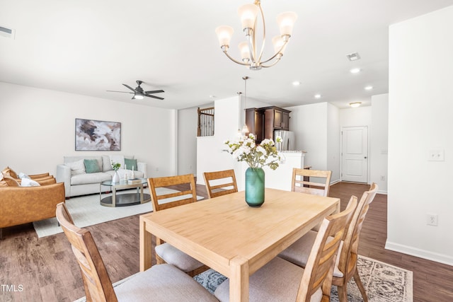 dining space with visible vents, wood finished floors, baseboards, recessed lighting, and ceiling fan with notable chandelier