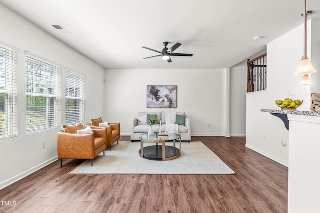 sitting room with a ceiling fan, baseboards, visible vents, and wood finished floors