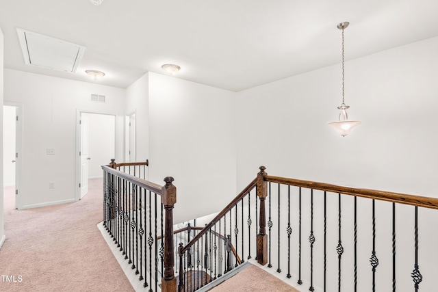 corridor with light colored carpet, attic access, baseboards, an upstairs landing, and visible vents