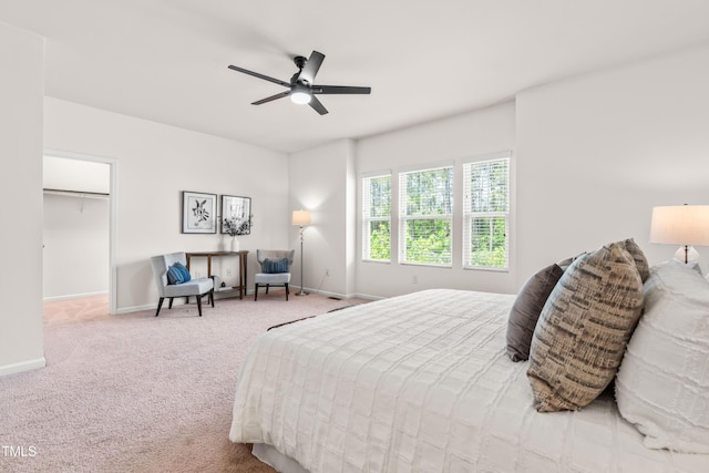 bedroom with carpet flooring, a ceiling fan, baseboards, and a spacious closet