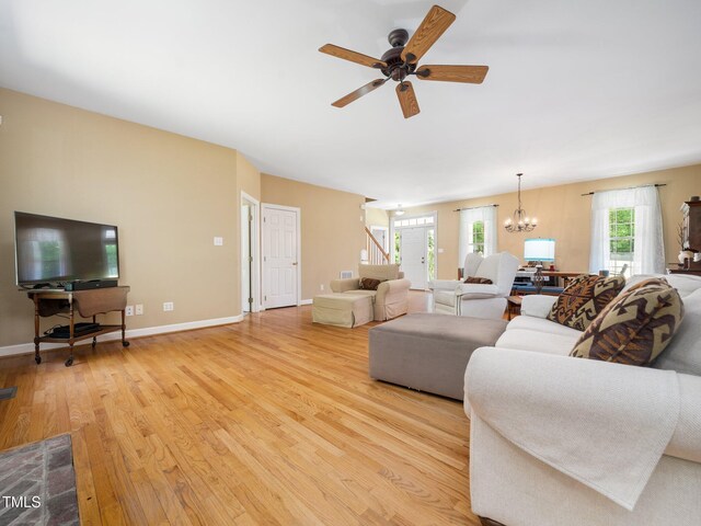 936 Elbridge Dr, Raleigh, NC 27603 - living area with light wood finished floors, stairs, ceiling fan, a chandelier, and baseboards