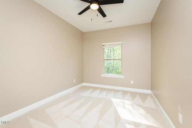 unfurnished room featuring baseboards, visible vents, a ceiling fan, and light colored carpet