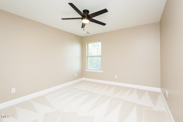 empty room featuring baseboards, a ceiling fan, and light colored carpet