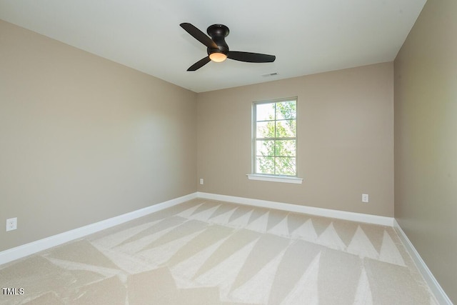 spare room featuring light carpet, baseboards, and visible vents