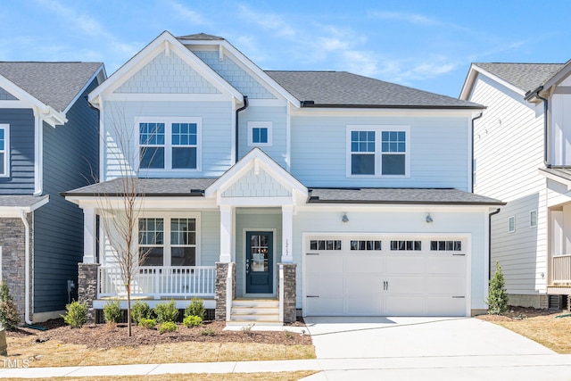 craftsman-style house featuring an attached garage, roof with shingles, covered porch, and driveway