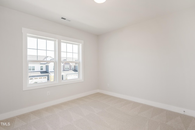 unfurnished room with light colored carpet, baseboards, and visible vents