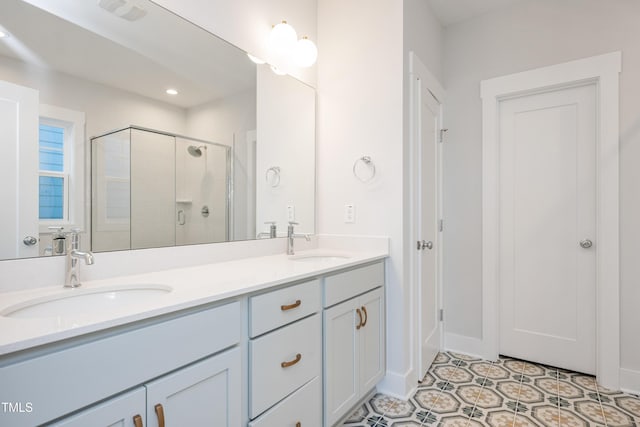 full bathroom with a sink, tile patterned flooring, a shower stall, and double vanity