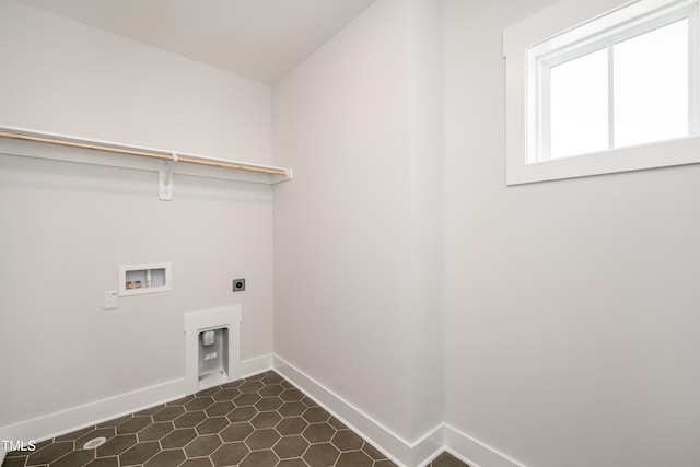 clothes washing area featuring dark tile patterned floors, electric dryer hookup, baseboards, washer hookup, and laundry area