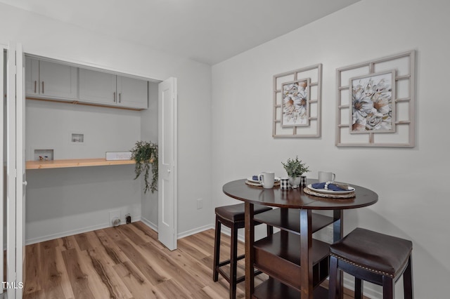 dining area featuring light wood-style flooring and baseboards
